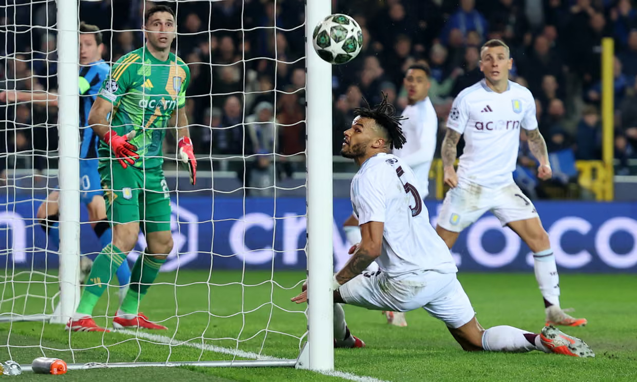 Emiliano Martínez and Tyrone Mings watch the ball drop in the Club Brugge goalmouth in the 2024-25 Champions League